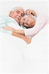 Elderly couple having a cuddle in bed