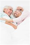 Elderly couple embracing in bed