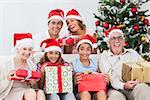 Happy family exchanging gifts at christmas time on the couch