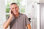 Smiling man on the phone in kitchen