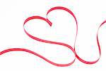 Pink ribbon shaped into heart on white background