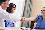 Nurse and doctor shaking hands during meeting