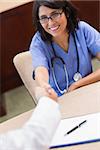 Happy nurse shaking doctors hand in a meeting