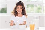 Little girl eating cereal with spoon