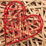 Red heart shaped ornamental box on wicker to the side