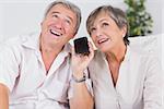Old couple listening to a smartphone looking up in the air