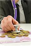 Closeup of financial adviser checking European union currency with stethoscope.