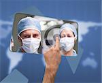 Hand selecting image of surgeons on touchscreen on blue map background