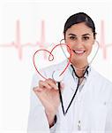 Happy doctor holding up stethoscope to red heart design on ECG line background