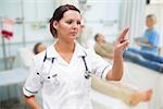 Nurse pressing on invisible screen in hospital ward