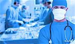 Doctor standing in operating room in front of an operation on a blue background