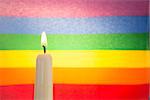 Candle against rainbow flag for gay pride