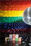 Blocks spelling out gay pride under light of disco ball with rainbow flag