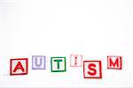 Autism spelled out in letter blocks on white background with copy space
