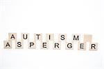 Autism and asperger spelled out in plastic letter pieces on white background