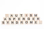 Autism asperger syndrome spelled out in plastic letter pieces on white background