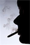 Close up silhouette of smoking man on white and grey background