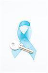 Blue ribbon for prostate cancer and silver key on white background