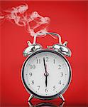 Smoking hot alarm clock on red background