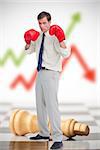 Businessman in boxing gloves on chessboard with red and green arrow in background