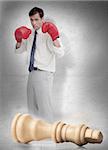 Businessman in red boxing gloves with knocked over white chess piece