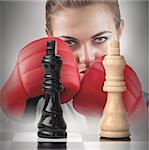 Female boxer with fists raised behind the chess board