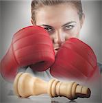 Powerful female boxer with knocked white chess piece on chessboard