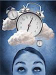 Woman looking up at alarm clock in clouds against blue background