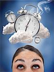 Woman looking up at ringing alarm clocks in clouds on blue background