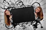 Girls pointing to black copy space with artistic swirl frame and grey paint splashes