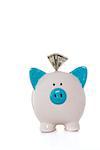 Dollar note sticking out of hand painted blue and white piggy bank on white background