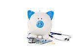Blue and white piggy bank sitting on euro notes with stethoscope syringe and pills