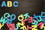 Alphabet magnets in a jumble on blackboard with Abc in order at the top