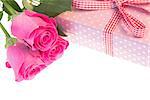 Pink roses resting on pink polka dot wrapped present with gingham ribbon with copy space