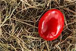 Red handpainted egg on straw
