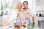 Happy family using futuristic interface to prepare dinner in the kitchen