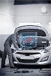 Man repairing car with open hood and futuristic interface showing map diagram