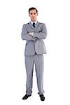 Serious businessman standing with his arms crossed on white background