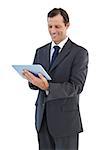 Smiling businessman holding a tablet pc on white background