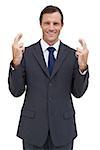 Serious businessman with fingers crossed on white background