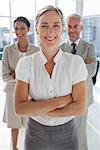 Cheerful team of business people standing together with their arms crossed