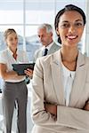 Proud businesswoman in front of colleagues working behind in their office