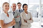 Smiling business people standing together with their arms crossed