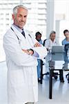 Doctor with arms crossed standing in front of medical team