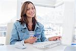 Attractive woman purchasing online with her credit card in modern office