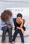 Woman crying next to her therapist who is comforting her