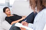 Woman lying on sofa and talking to therapist