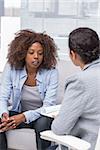 Patient sitting on sofa and talking to therapist during therapy