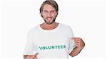 Man pointing to his volunteer tshirt on white background