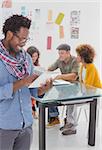 Designer standing and using his tablet in creative office